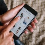 Een persoon is online aan het shoppen op de mobiele telefoon.