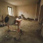 Renovatie en onderhoud kosten zichtbaar met betonmolen in lege woning tijdens verbouwing